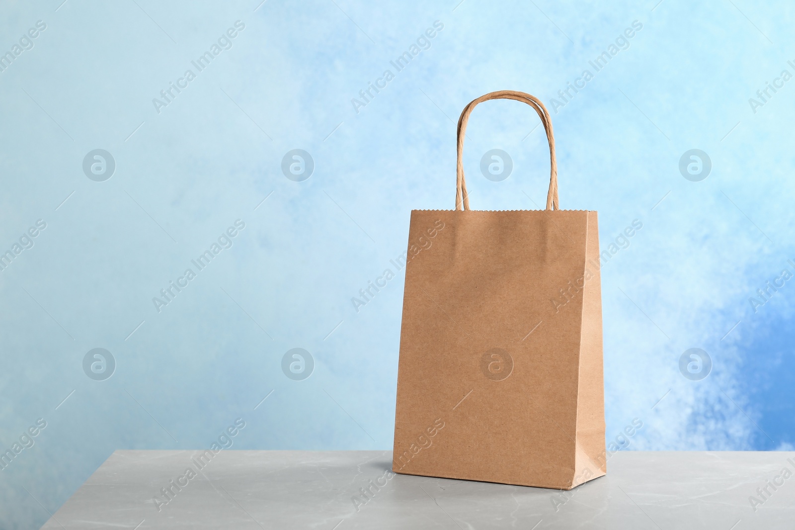 Photo of Mockup of paper shopping bag on table against color background