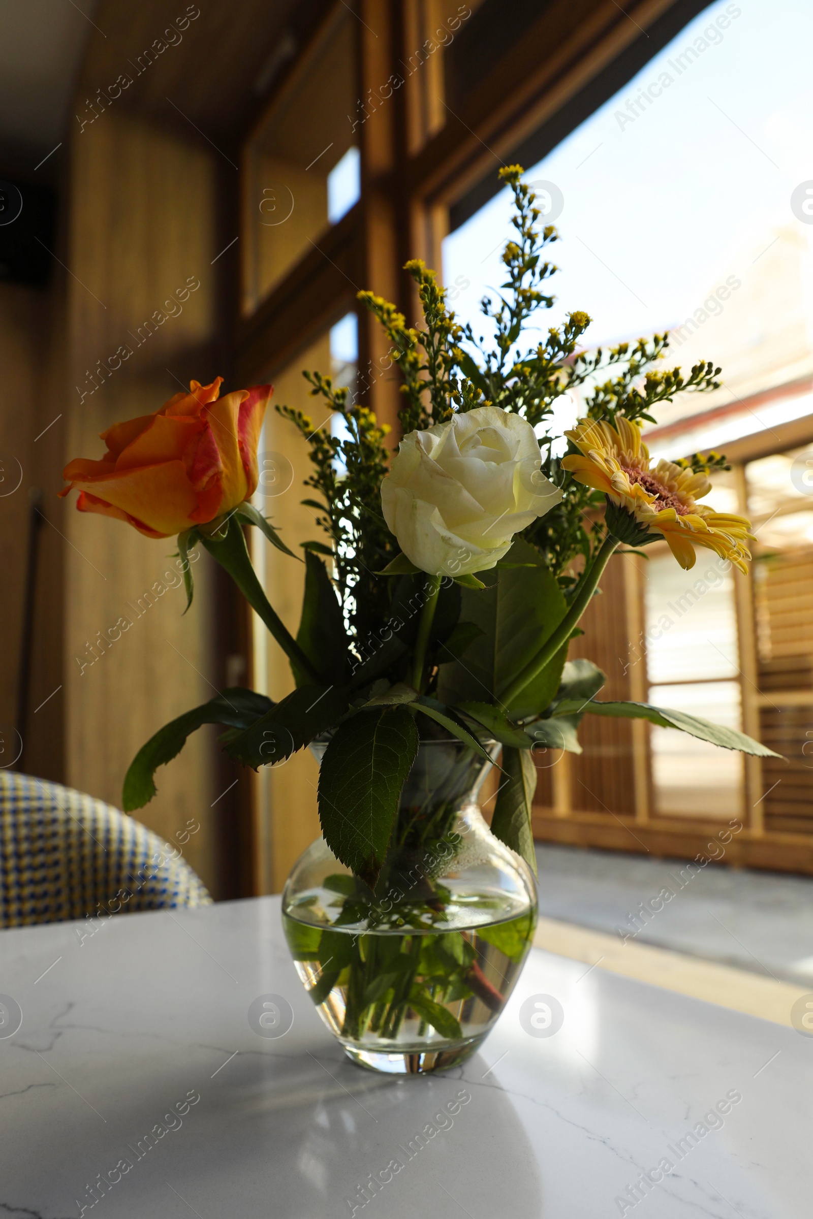 Photo of Bouquet of beautiful flowers on table indoors