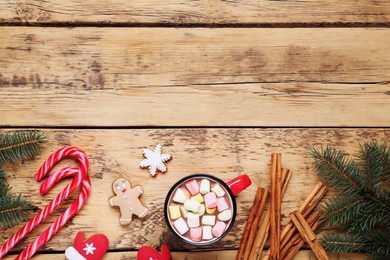 Photo of Delicious hot chocolate with marshmallows and gingerbread cookies on wooden table, flat lay. Space for text