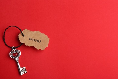 Photo of Vintage key with tag on red background, top view and space for text. Keyword concept