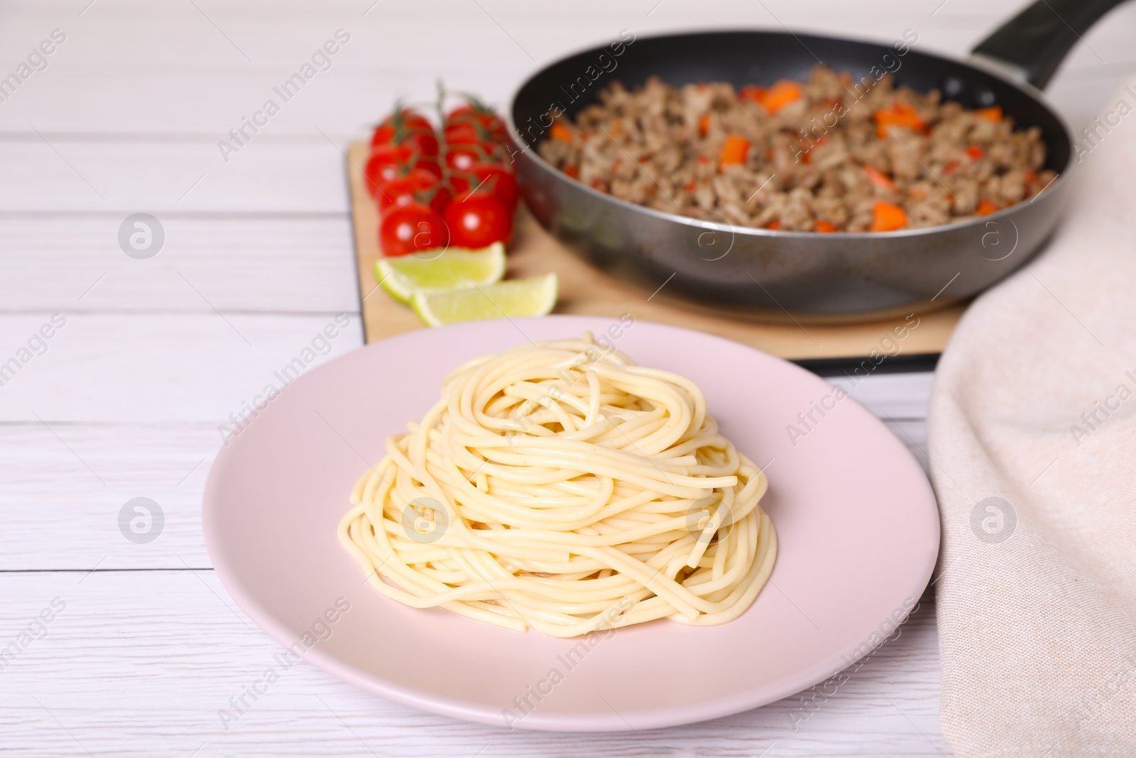 Photo of Delicious spaghetti, minced meat and tomatoes on white wooden table