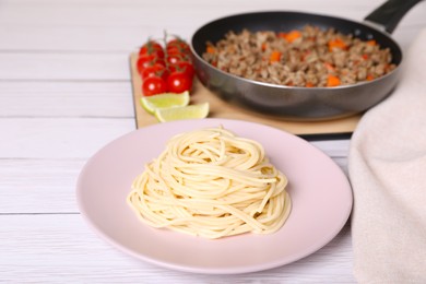 Photo of Delicious spaghetti, minced meat and tomatoes on white wooden table