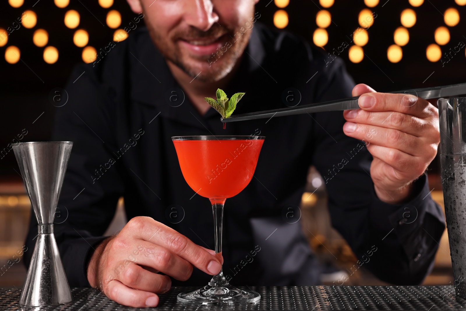 Photo of Bartender preparing fresh alcoholic cocktail in bar, closeup