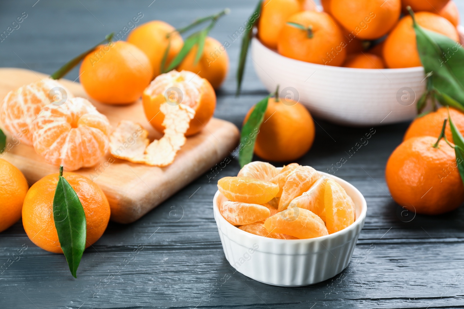 Photo of Fresh tangerine slices on grey wooden table