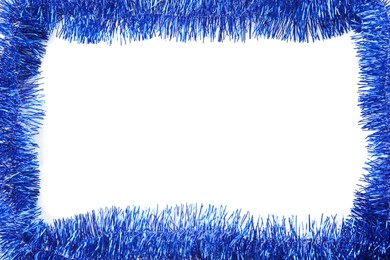 Photo of Frame of shiny blue tinsel on white background, top view. Space for text