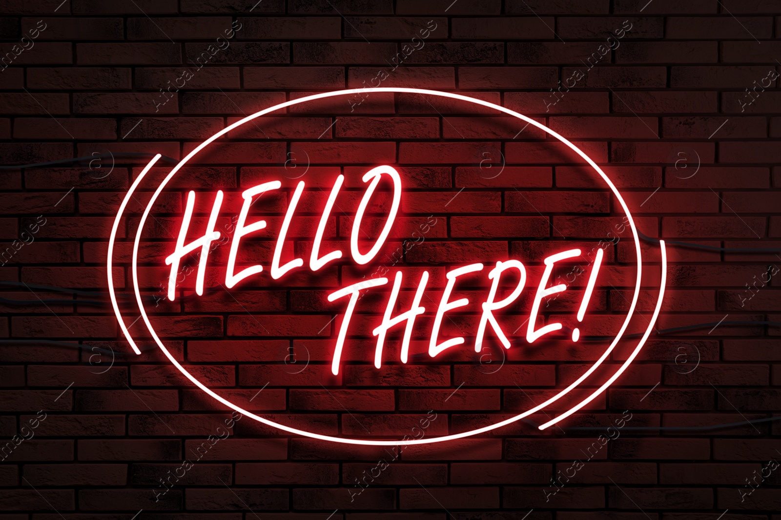 Image of Stylish neon sign with phrase Hello there on brick wall