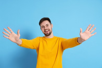 Photo of Man giving high five on light blue background