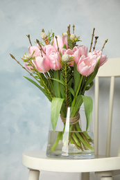 Photo of Beautiful bouquet with spring pink tulips on white chair