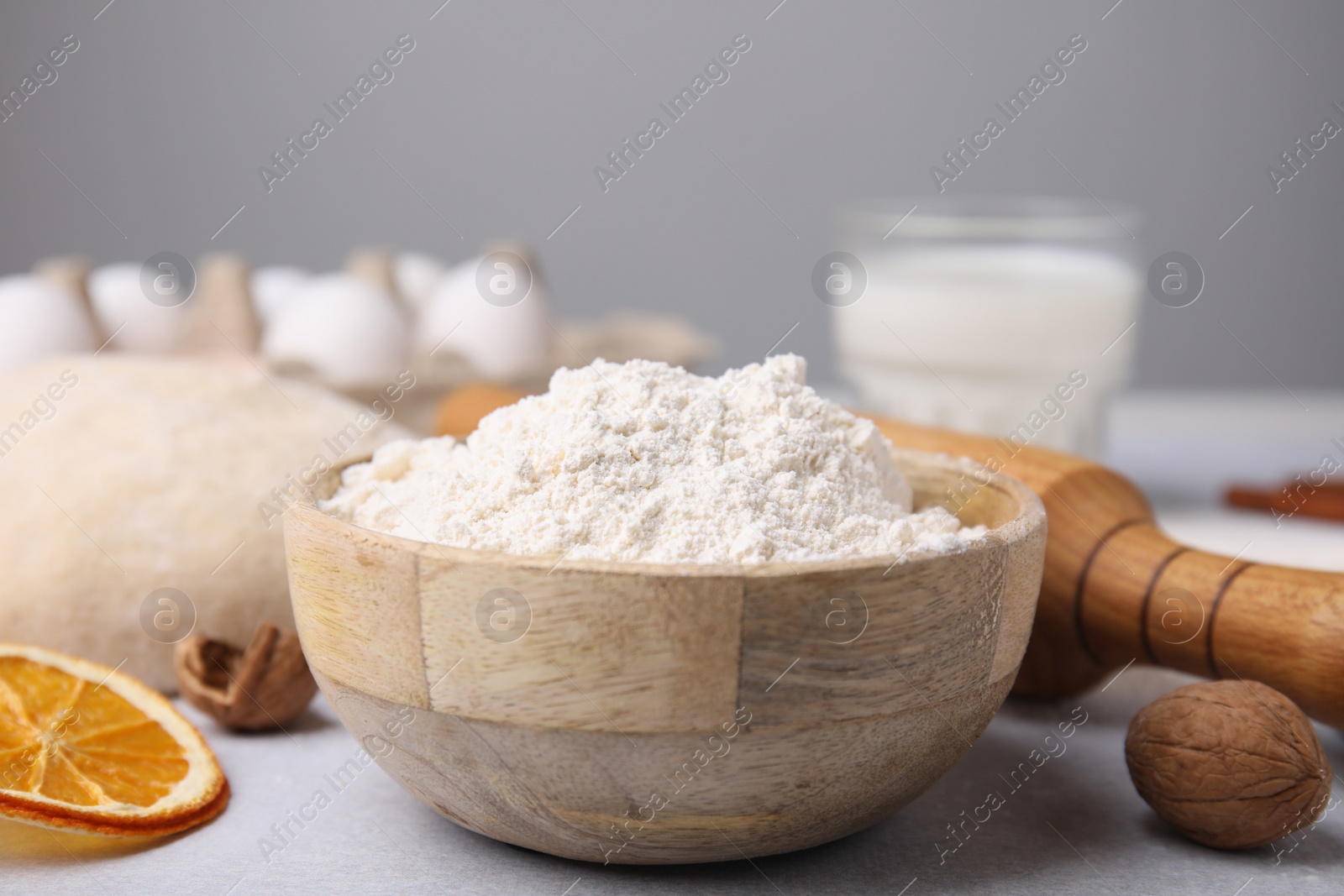Photo of Bowl of flour and other ingredients on white table