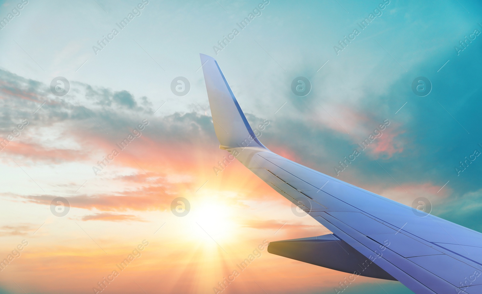 Image of Airplane flying in sky at sunset, view on wing. Air transportation