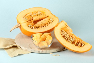 Photo of Cut fresh ripe pumpkin on light blue background