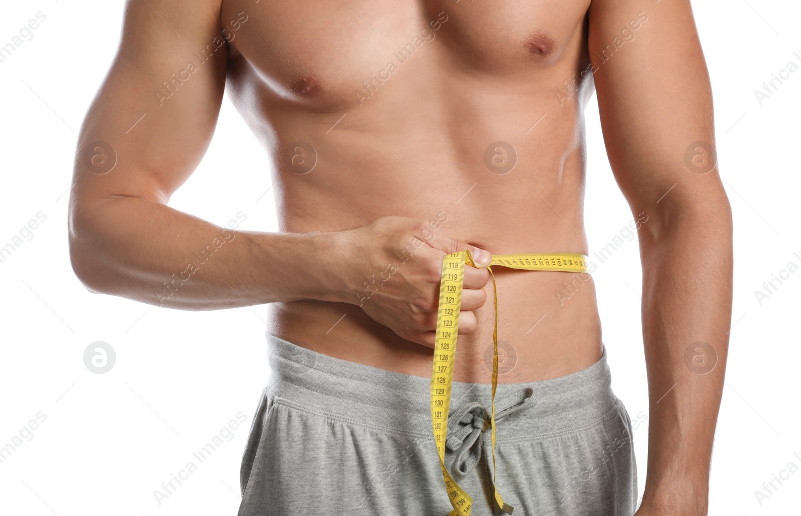 Photo of Young man with slim body using measuring tape on white background, closeup view