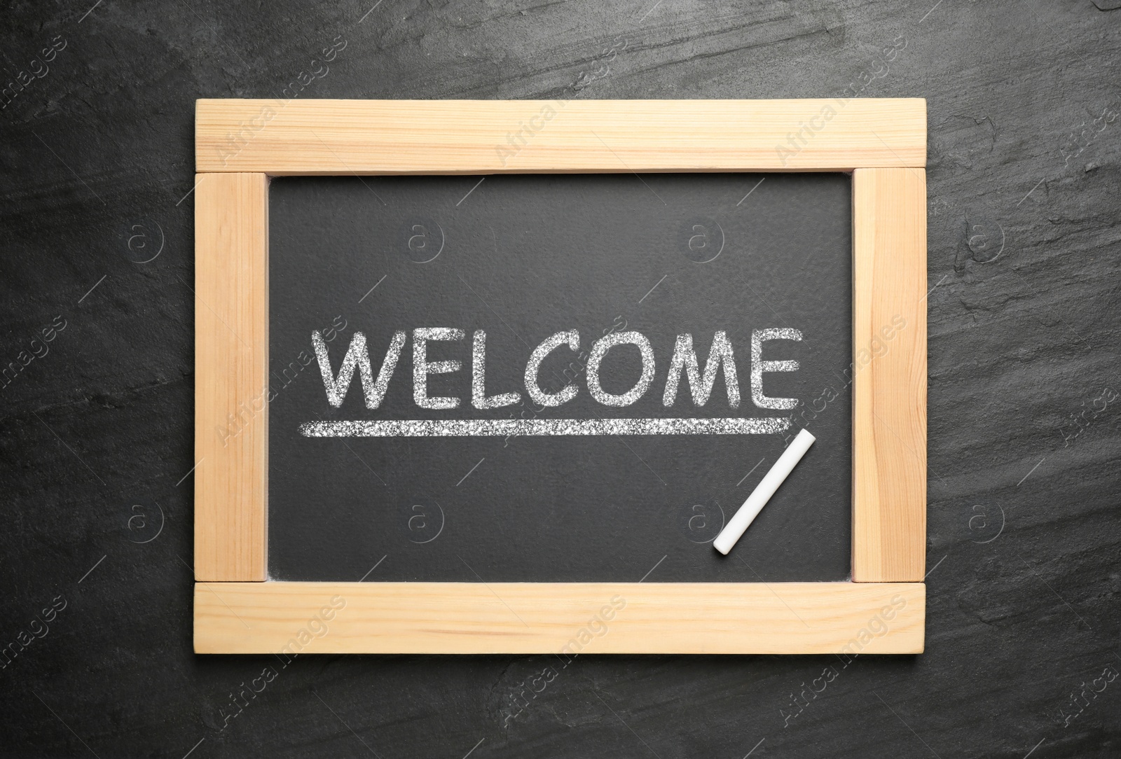 Image of Blackboard with word WELCOME and chalk on slate background, top view