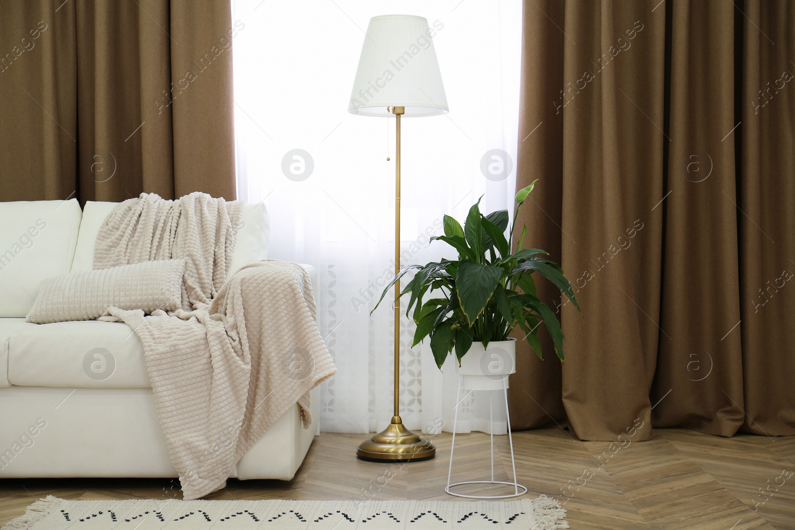 Photo of Sofa and window with brown curtains in simple room interior