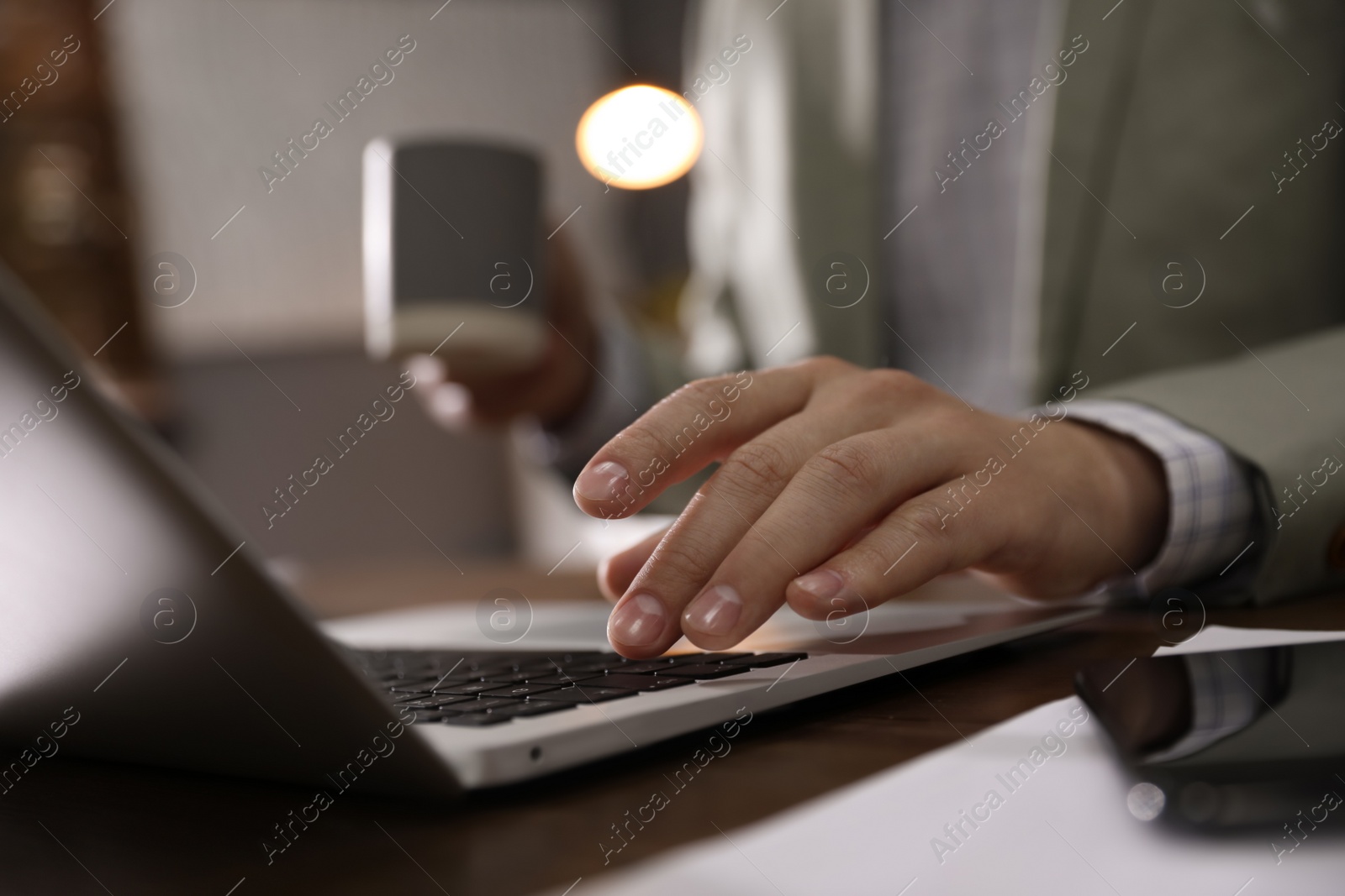 Photo of Man working with laptop in office, closeup of hand