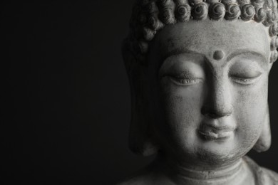 Photo of Beautiful stone Buddha sculpture on black background, closeup. Space for text