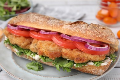 Delicious sandwich with schnitzel on white wooden table, closeup