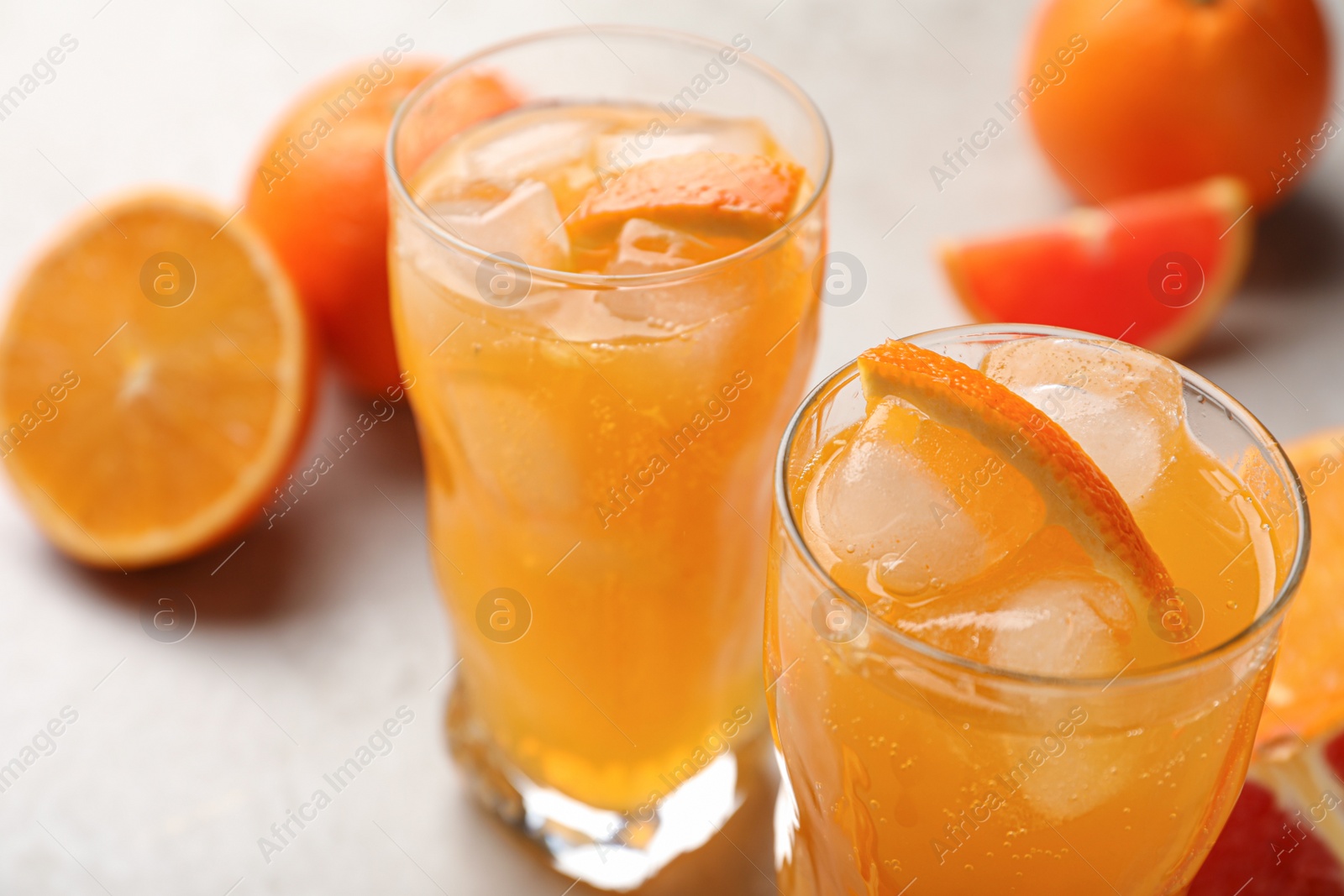 Photo of Delicious orange soda water on light table, closeup