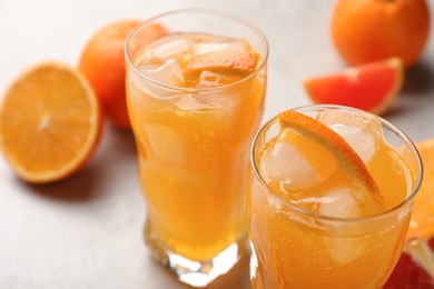 Photo of Delicious orange soda water on light table, closeup