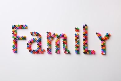 Word Family made of melty beads on white background, flat lay