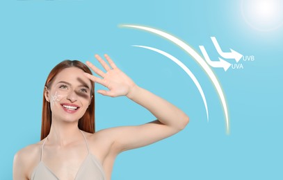 Sun protection product as barrier against UVA and UVB. Beautiful young woman with sunscreen on face shading herself with hand against light blue background