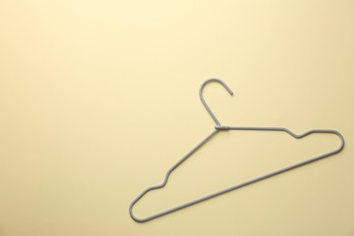 Photo of Hanger on pale yellow background, top view. Space for text