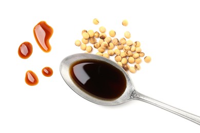 Photo of Tasty soy sauce in spoon and soybeans isolated on white, top view