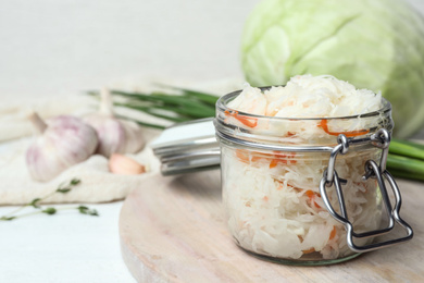 Photo of Tasty fermented cabbage on white wooden table, closeup