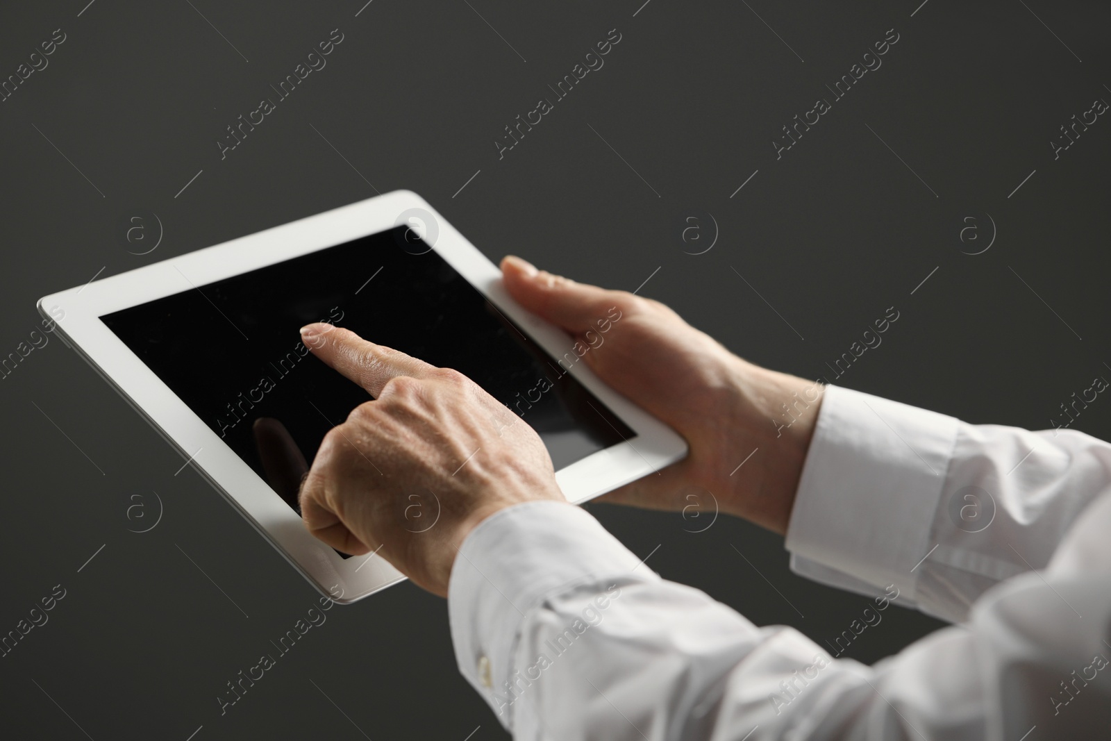Photo of Closeup view of man using new tablet on grey background
