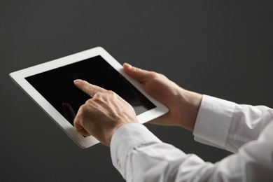 Closeup view of man using new tablet on grey background