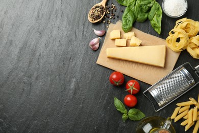 Photo of Different types of pasta, spices, garter and products on dark textured table, flat lay. Space for text