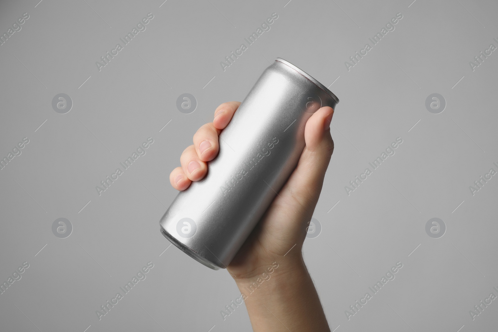 Photo of Woman holding aluminum can with beverage on grey background, closeup. Space for design