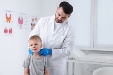 Endocrinologist examining boy's thyroid gland at hospital