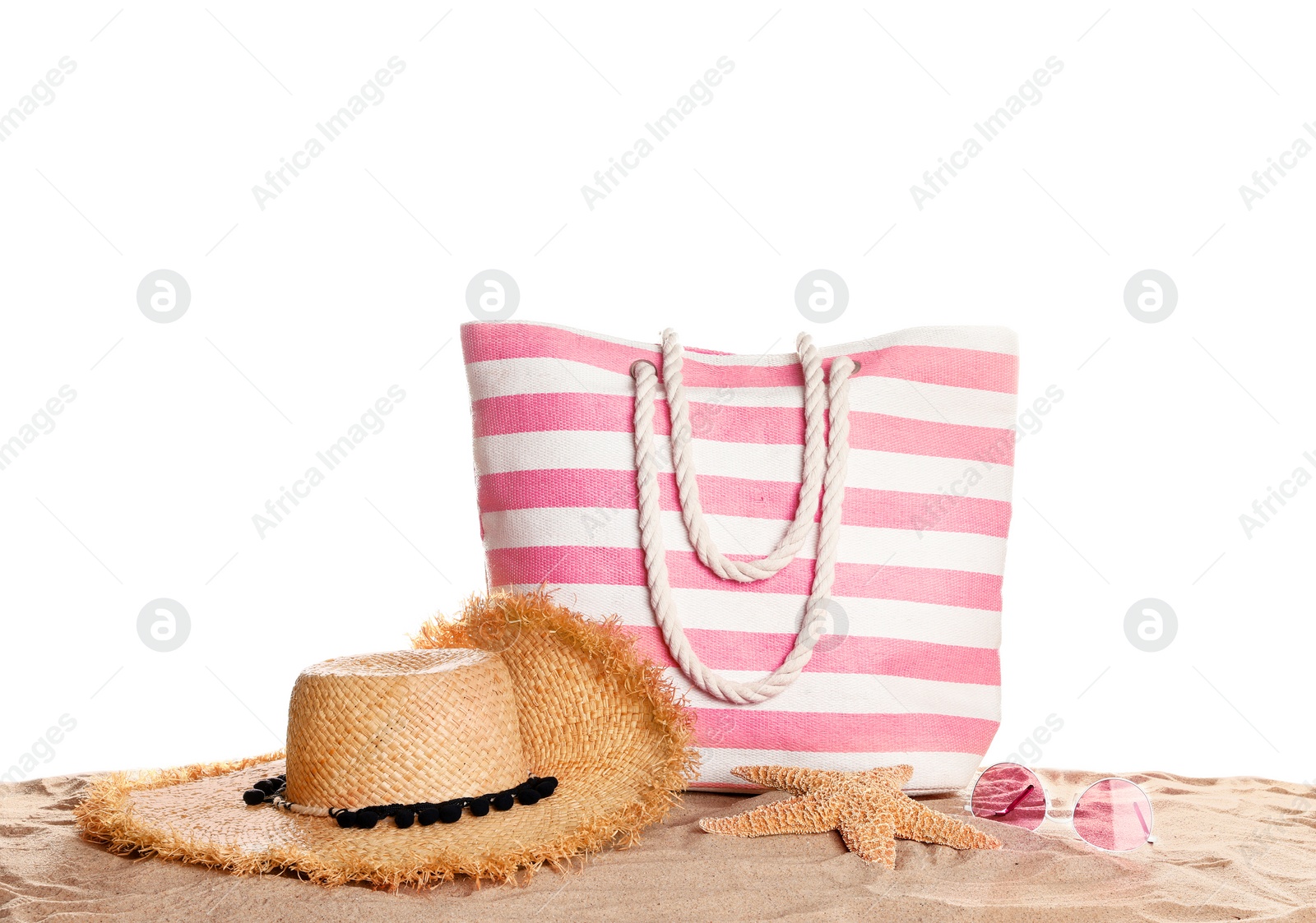 Photo of Stylish striped bag and beach accessories on sand against white background