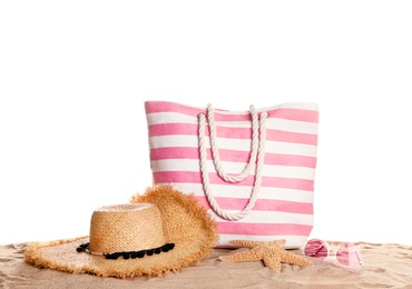 Photo of Stylish striped bag and beach accessories on sand against white background