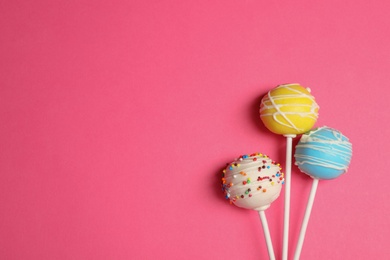 Photo of Bright delicious cake pops on color background, flat lay. Space for text