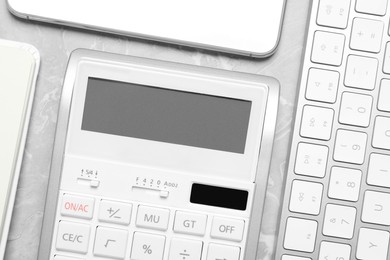 Photo of Calculator, smartphone and keyboard on grey table, flat lay. Tax accounting