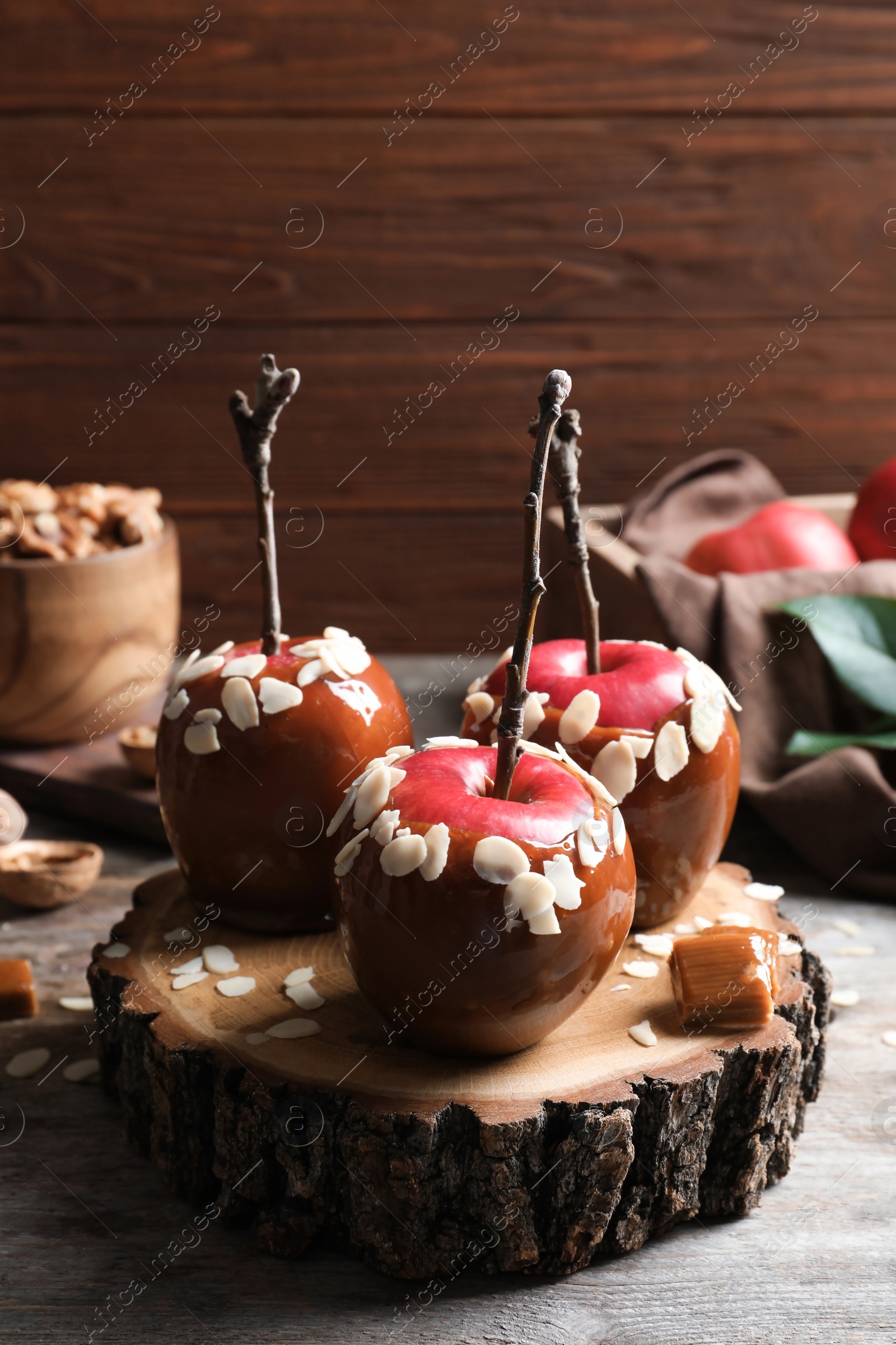 Photo of Delicious caramel apples on wooden serving board