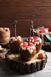 Photo of Delicious caramel apples on wooden serving board