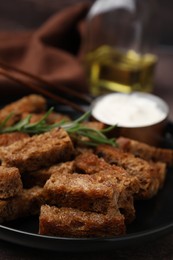Photo of Crispy rusks with rosemary on plate, closeup