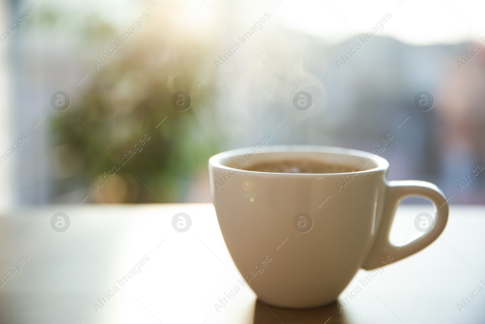 Photo of Cup of hot drink on table in morning