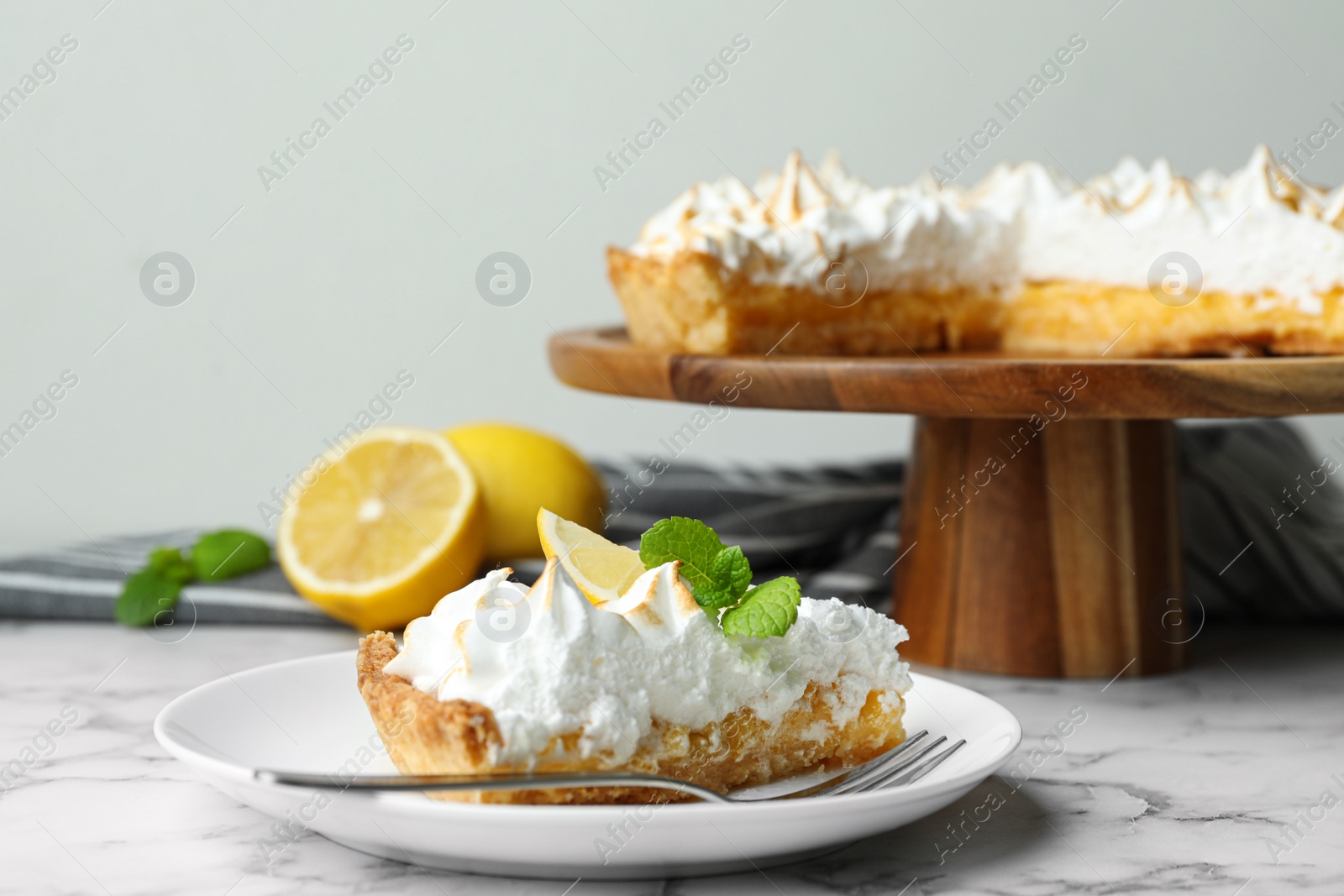 Photo of Delicious lemon meringue pie served on white marble table