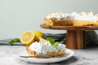 Photo of Delicious lemon meringue pie served on white marble table