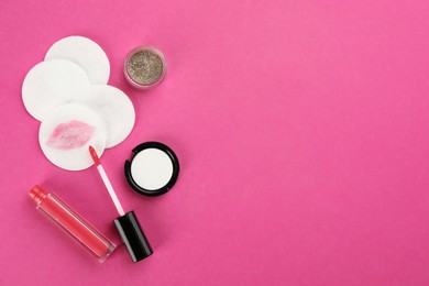 Photo of Dirty cotton pads and cosmetic products on pink background, flat lay. Space for text