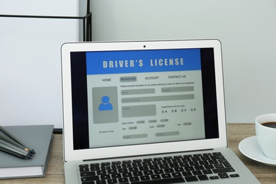 Laptop with driver's license application form on table in office