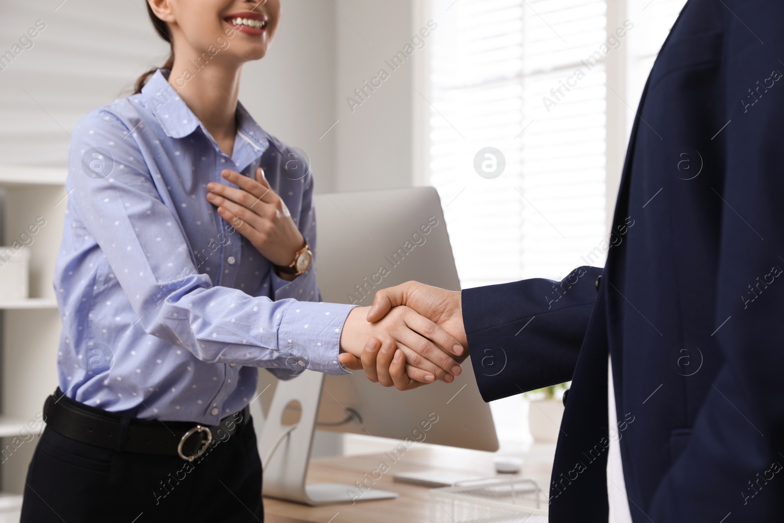 Photo of Man shaking hands with intern in office, closeup