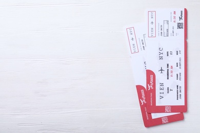 Photo of Tickets on white wooden table, flat lay with space for text. Travel agency concept