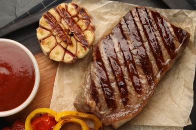 Photo of Delicious grilled beef steak with spices and tomato sauce on table, top view