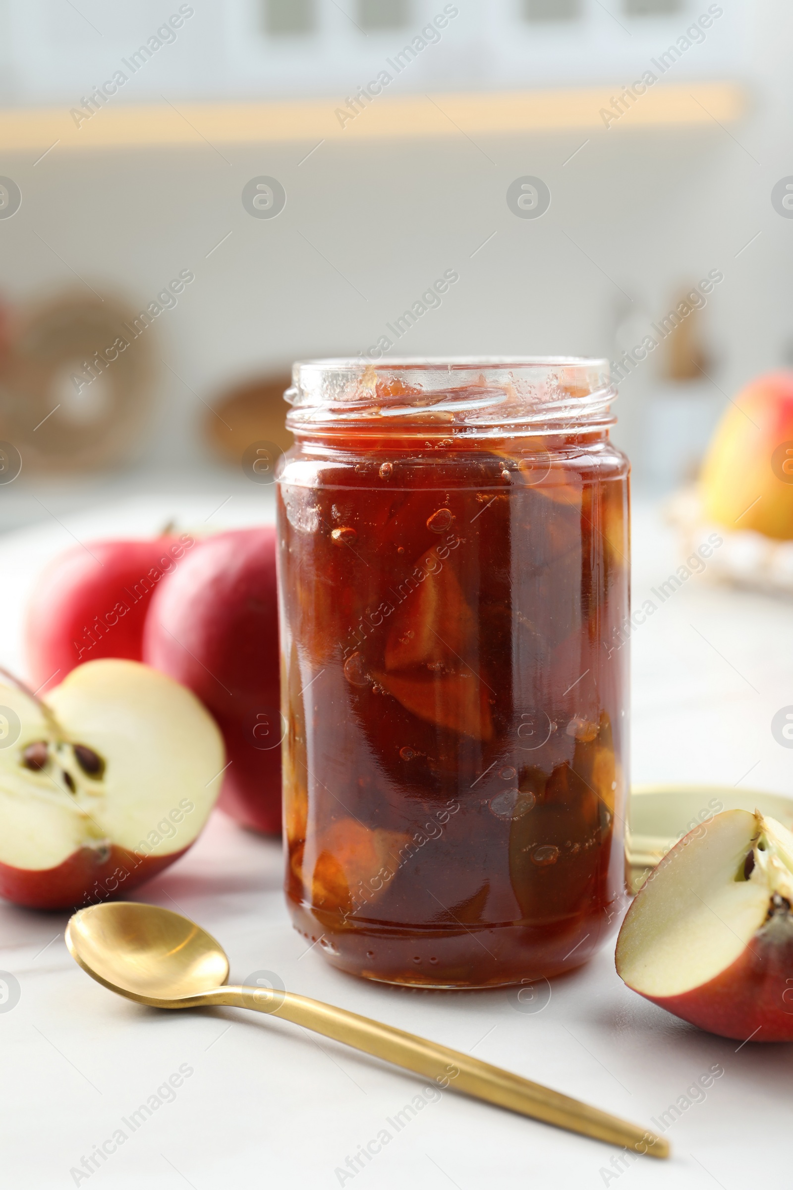 Photo of Delicious apple jam in jar and fresh fruits on white table