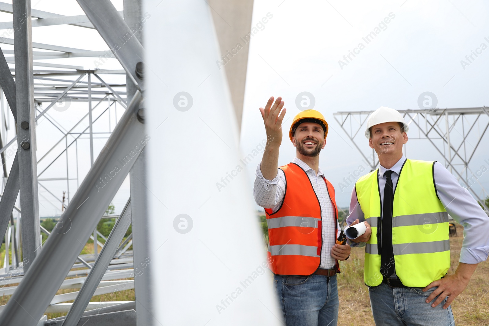 Photo of Professional engineers working on installation of electrical substation outdoors